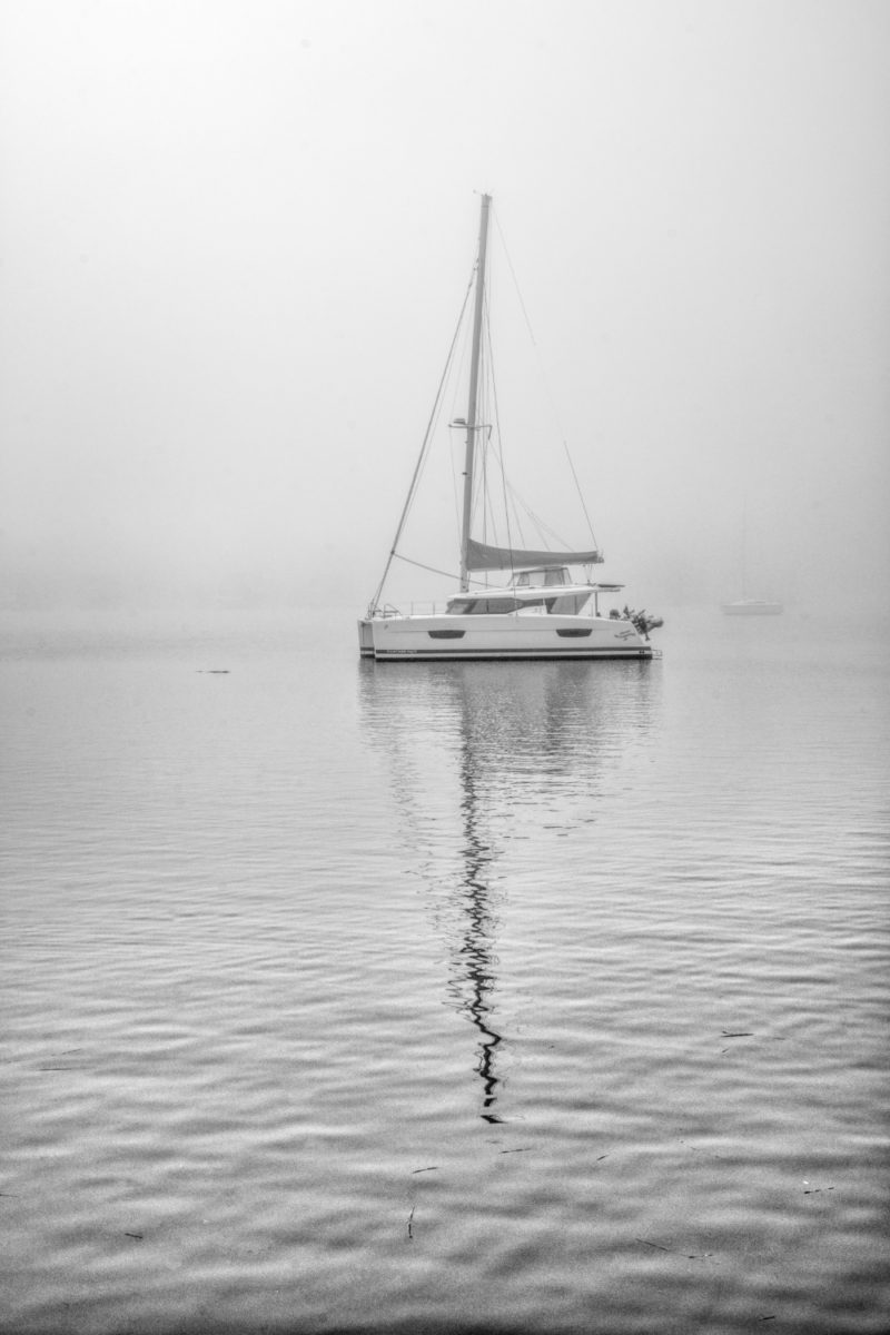 Black and white photo of sailboat in fog
