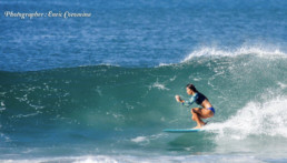 Costa RIcan woman surfs a green wave.